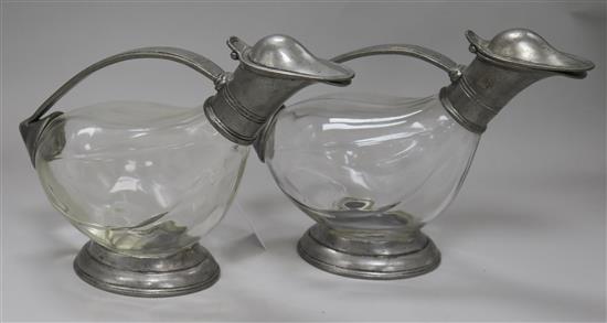 A pair of pewter mounted glass claret jugs